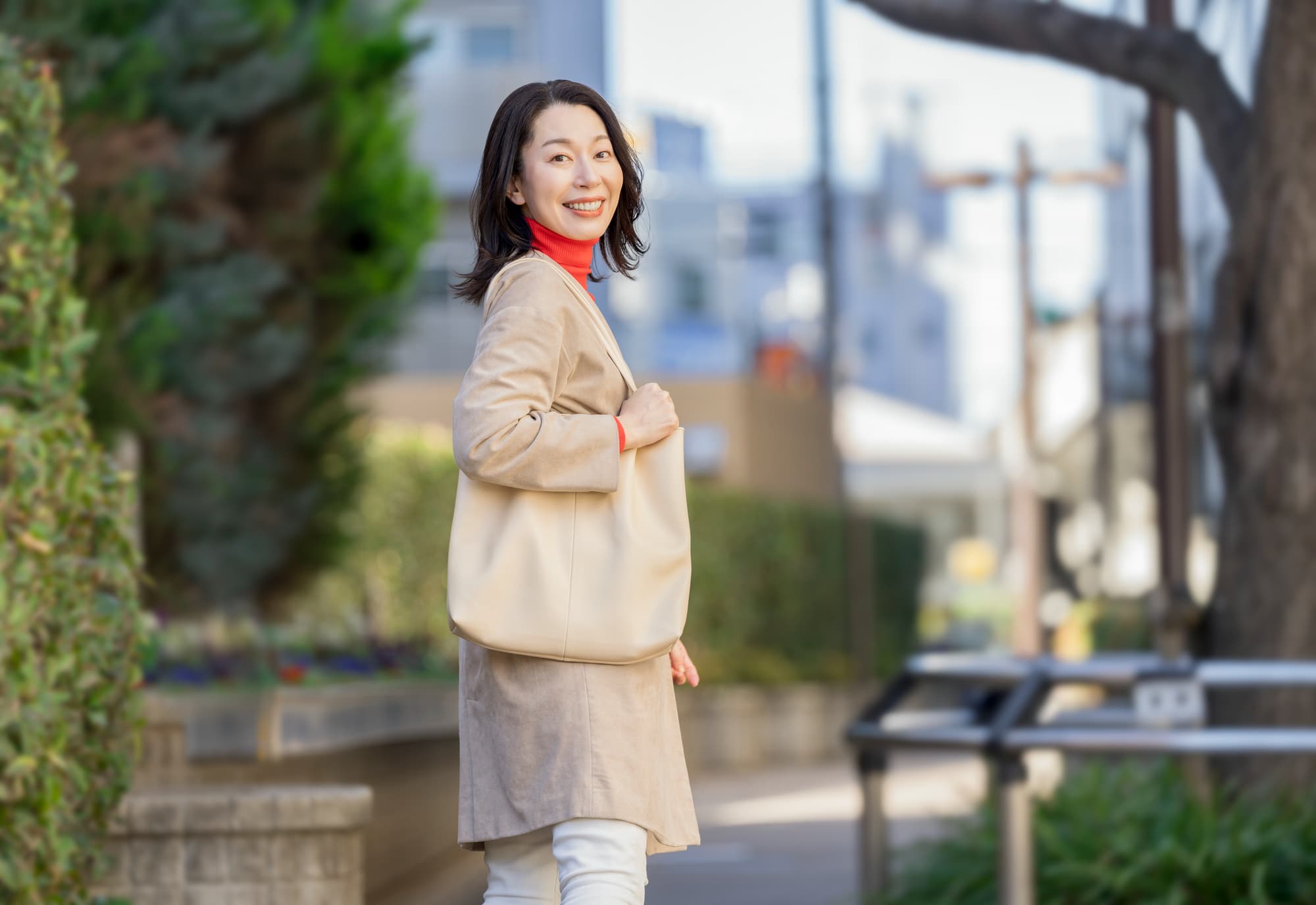 さわやかな笑顔でこちらを振り返るミドル世代の女性
