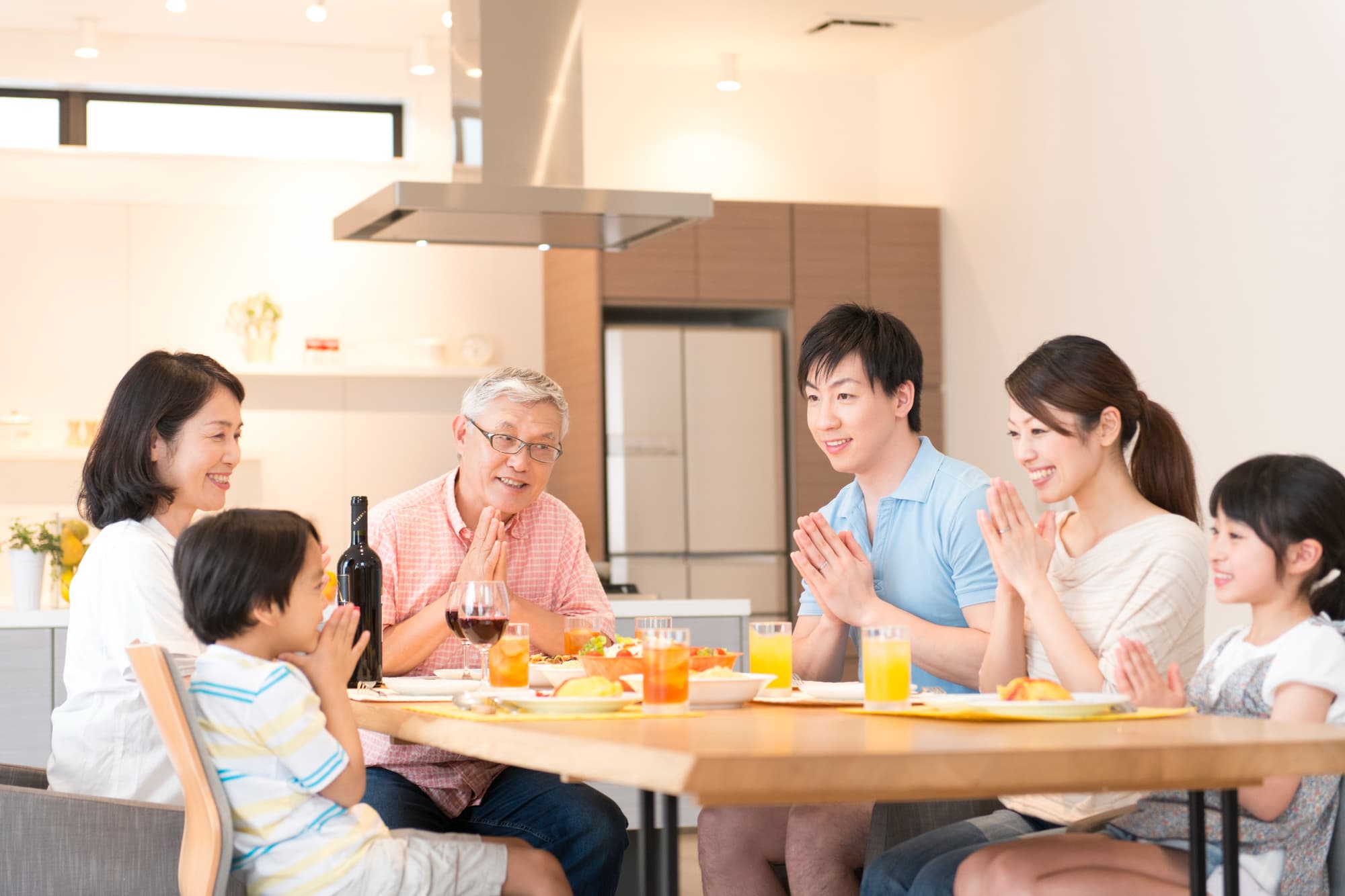 食卓を囲みいただきますをする三世代家族